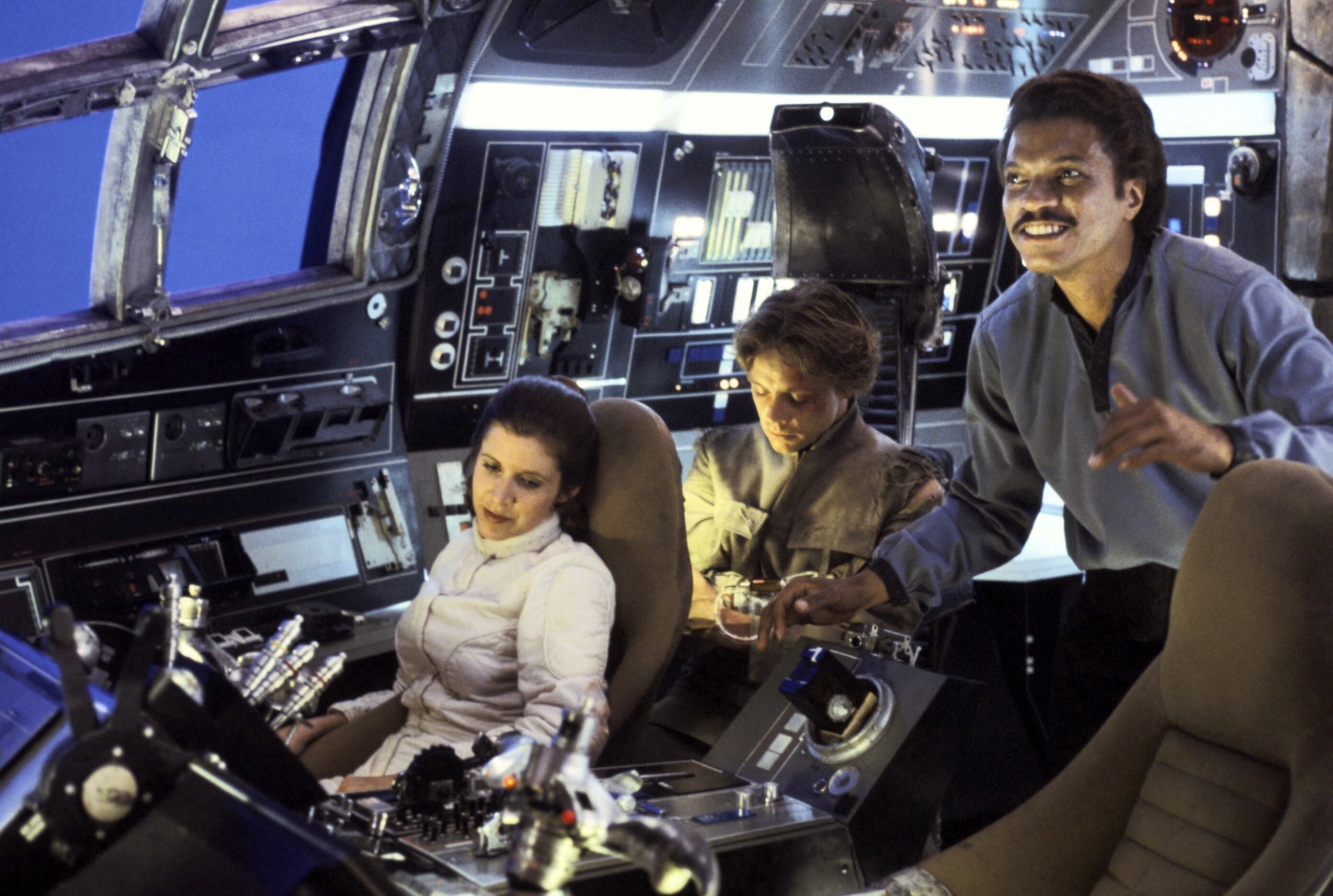 Carrie Fisher, Mark Hamill, and Billy Dee Williams in the cockpit of the Millennium Falcon, betwe...