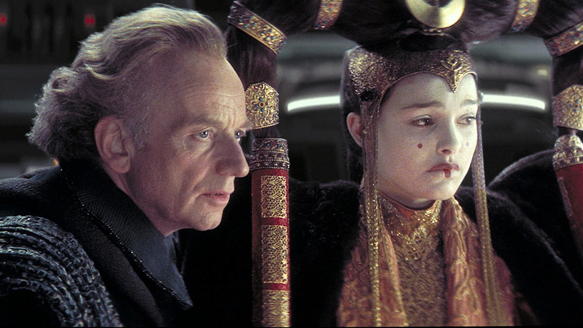 Senator Palpatine advising Queen Amidala during a session of the Senate