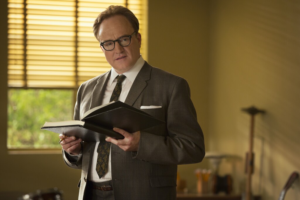 Actor Bradley Whitford as Don DaGradi standing with an open book in the movie "Saving Mr. Banks".