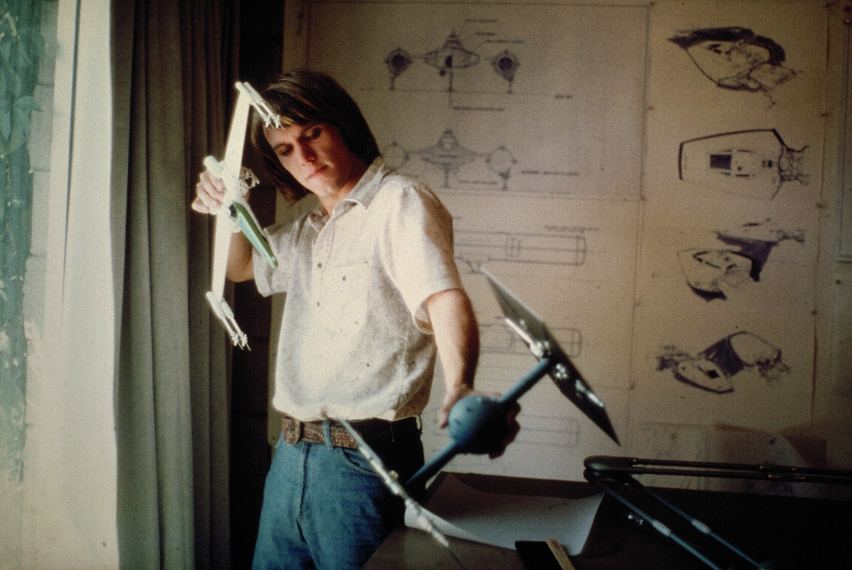 Concept artist and effects technician Joe Johnston with X-wing and TIE fighter models.
