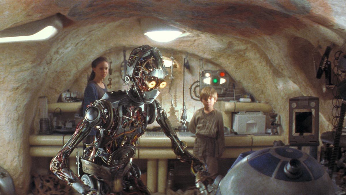 C-3PO greeting R2-D2 as Anakin and Padme observe