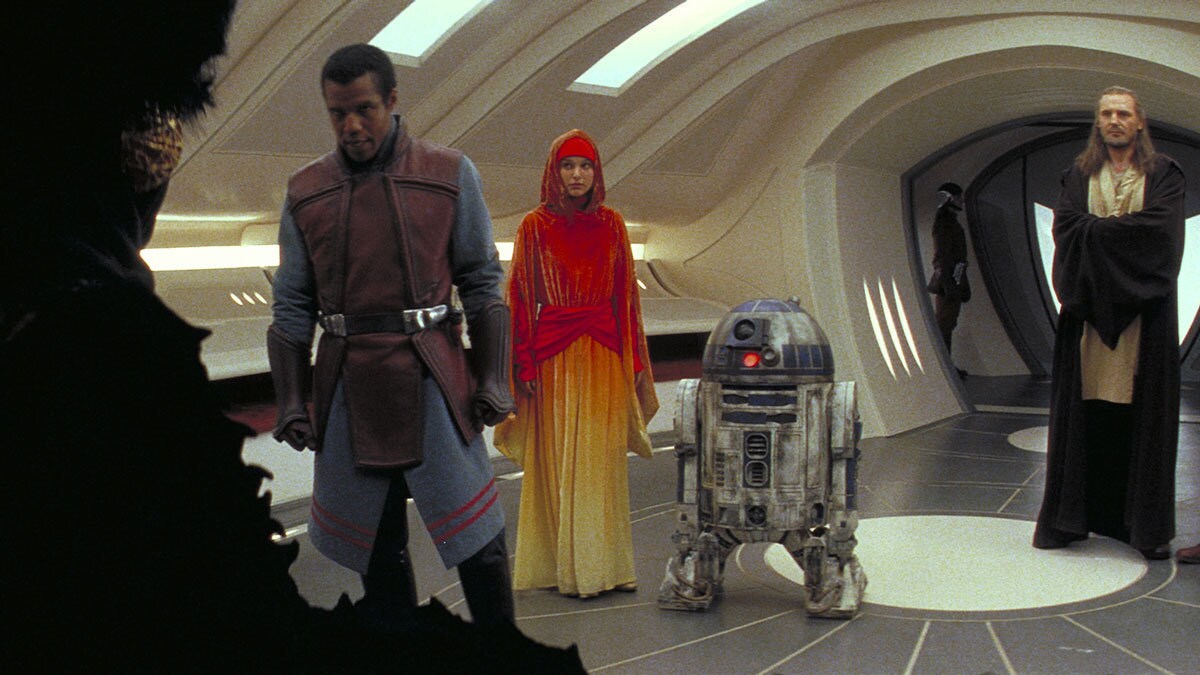 Captain Panaka, a handmaiden, R2-D2, and Qui-Gon Jinn addressing the Queen of Naboo