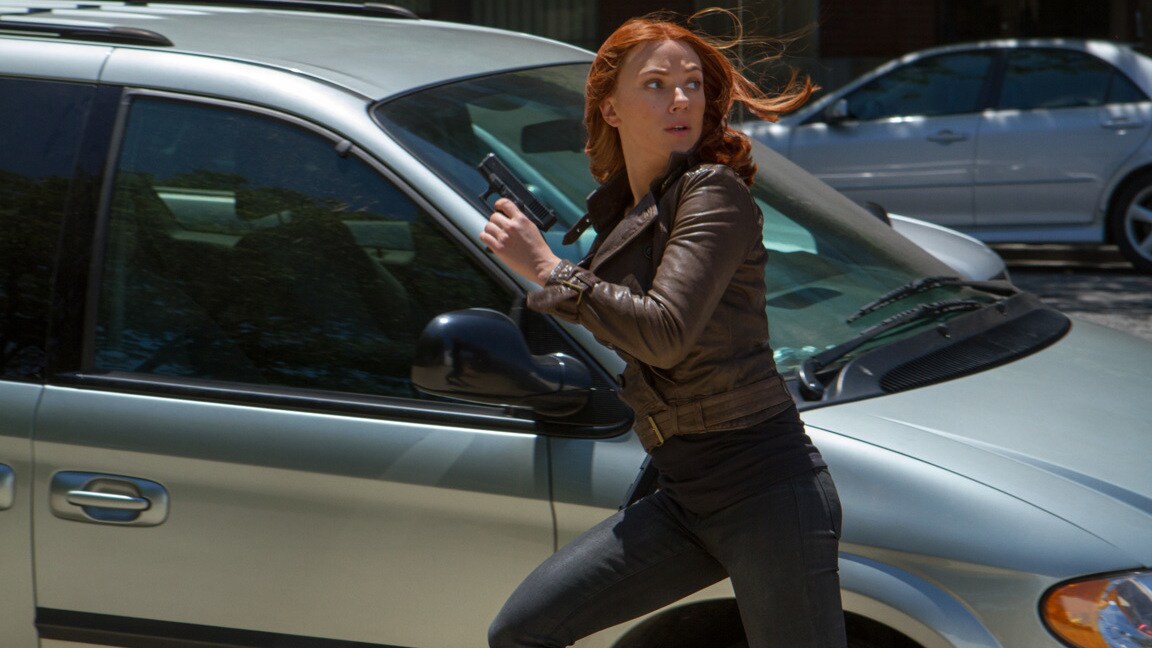 Actor Scarlett Johansson (Natasha Romanoff/Black Widow) running past a car in Captain America: The Winter Soldier.