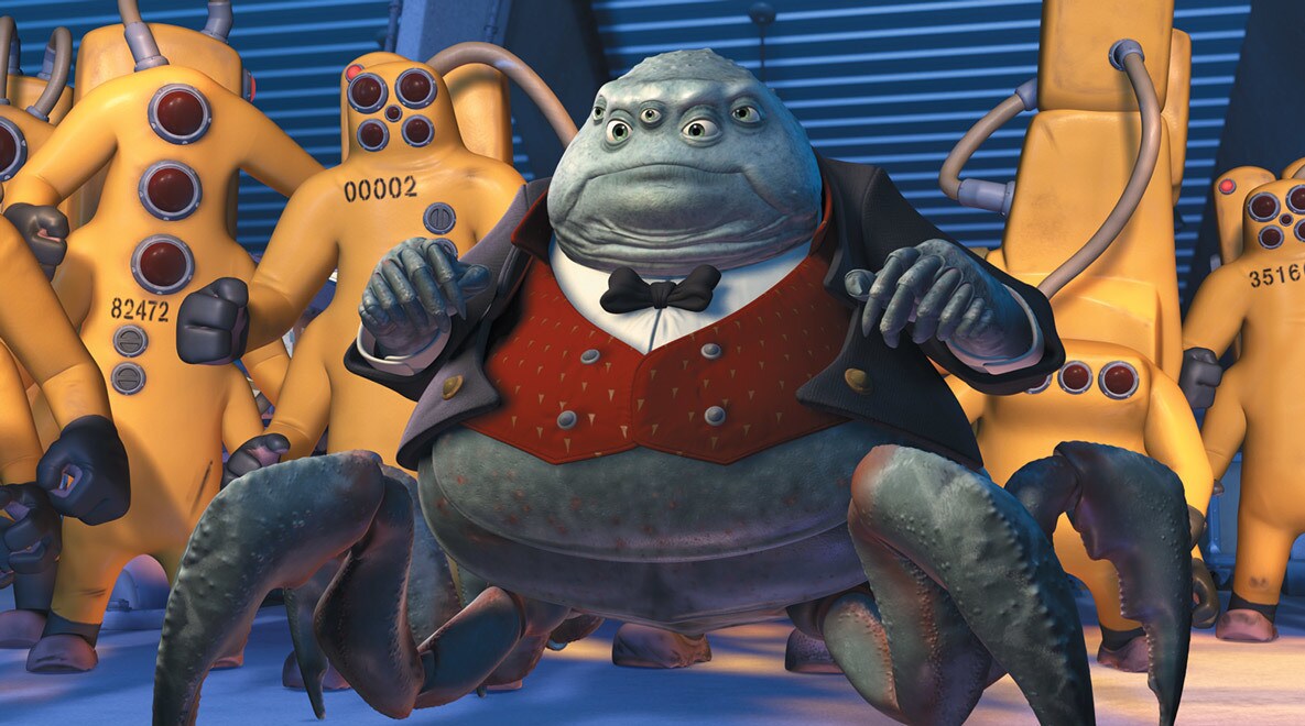 James Coburn as Mr. Waternoose surrounded by workers in Monsters, Inc.