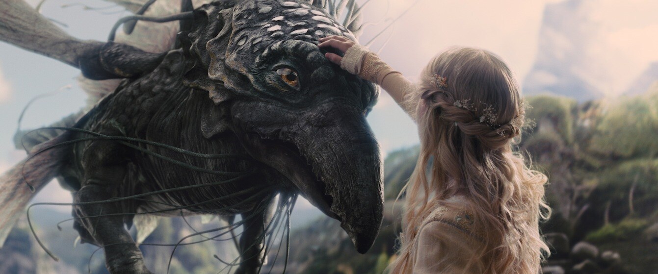 Elle Fanning as Aurora petting a flying creature in the movie "Maleficent"