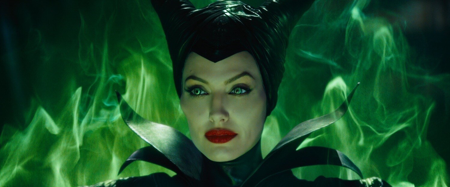 Angelina Jolie as Maleficent, surrounded by green smoke, in the movie "Maleficent"