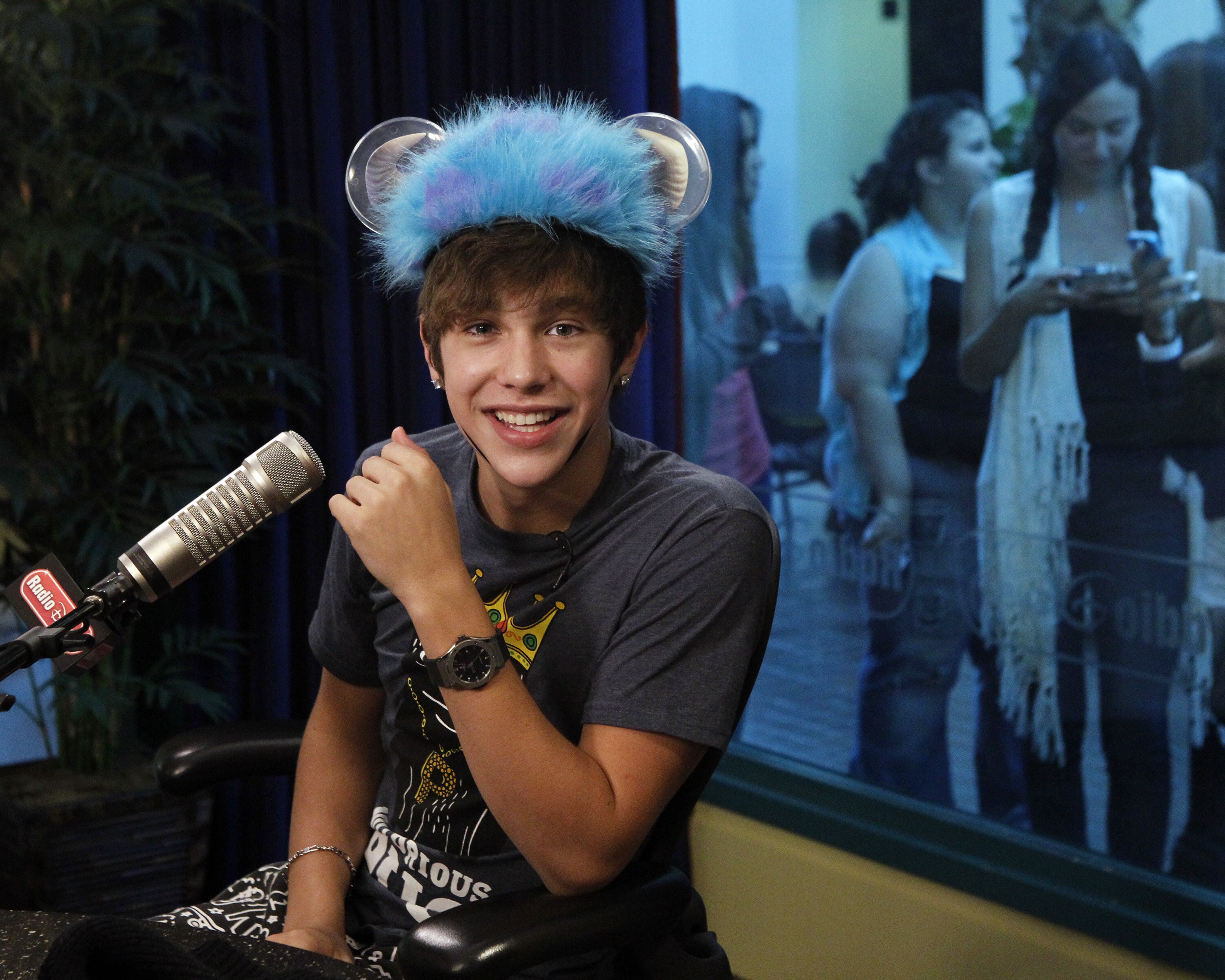 Austin tries on a new hat in the Radio Disney studio