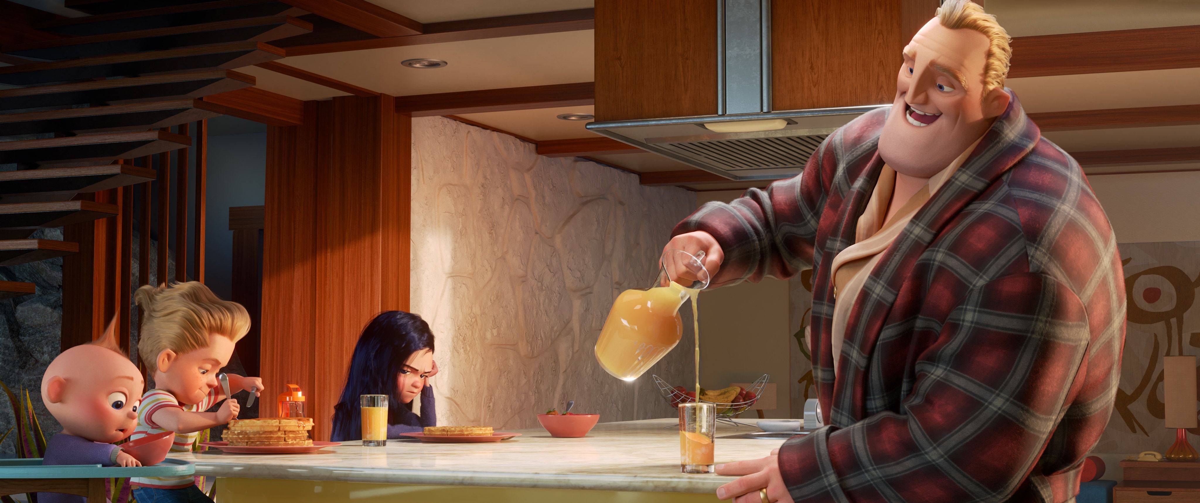 A father with blond hair pours orange juice in a kitchen for his 3 kids: a teen girl, a ten-year-old boy, and a baby