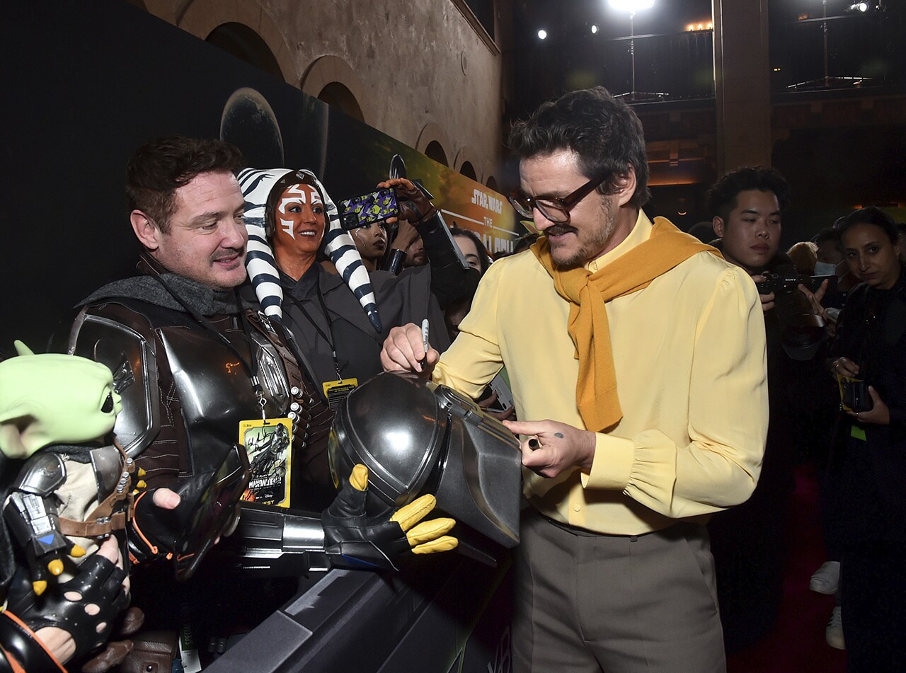 Pedro Pascal signing a Mandalorian helmet