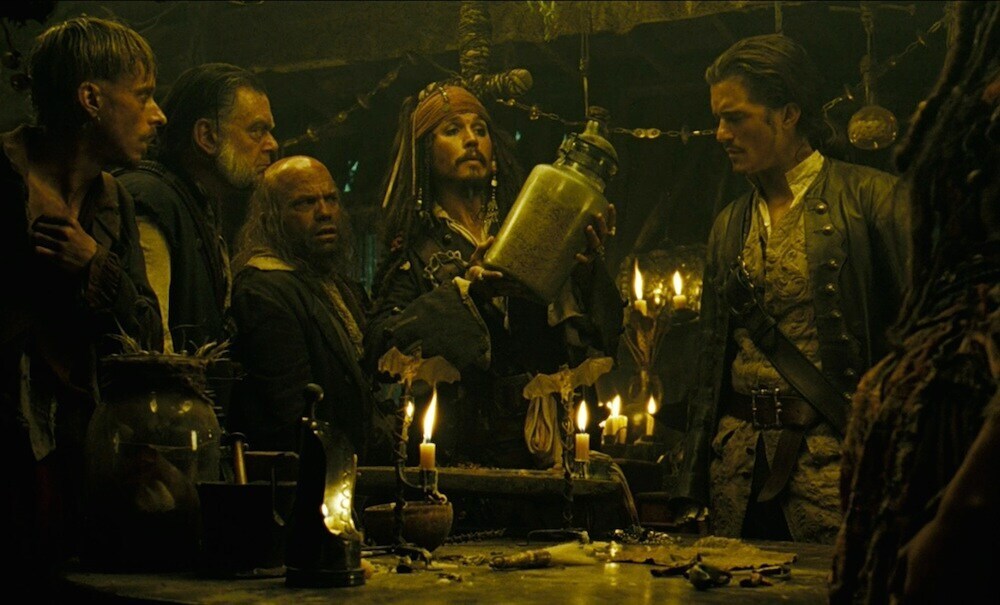 Captain Jack Sparrow (played by Johnny Depp) and crew looking at a jar from the movie "Pirates of the Caribbean"