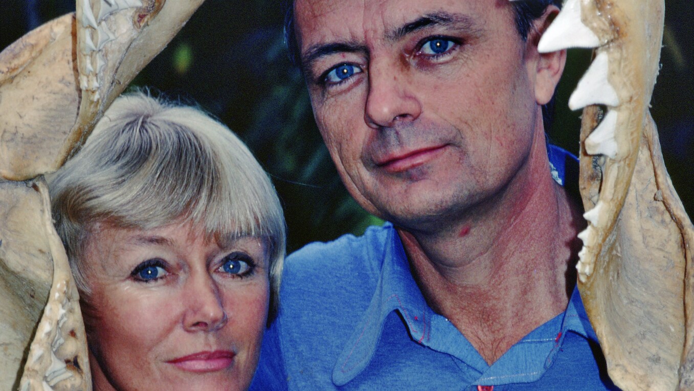 Ron & Valerie Taylor framed by a shark jaw skeleton.  (photo credit: Ron & Valerie Taylor)