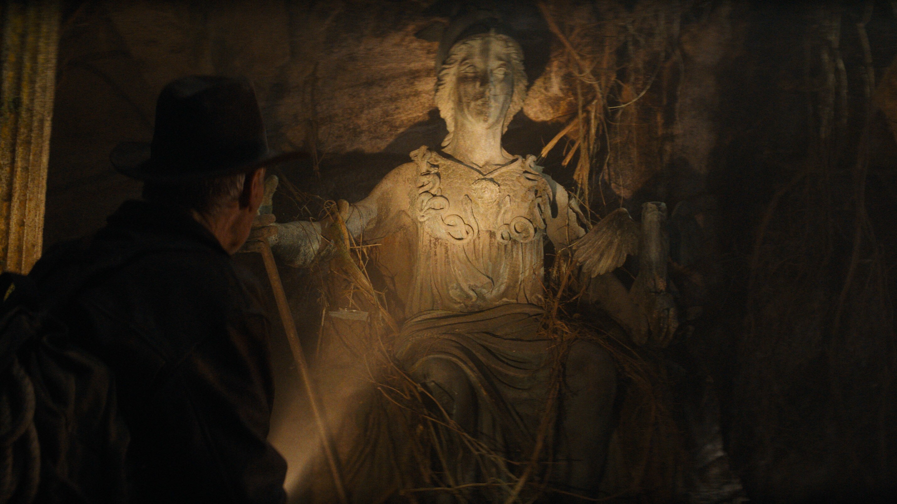 Indiana Jones looking at statue.