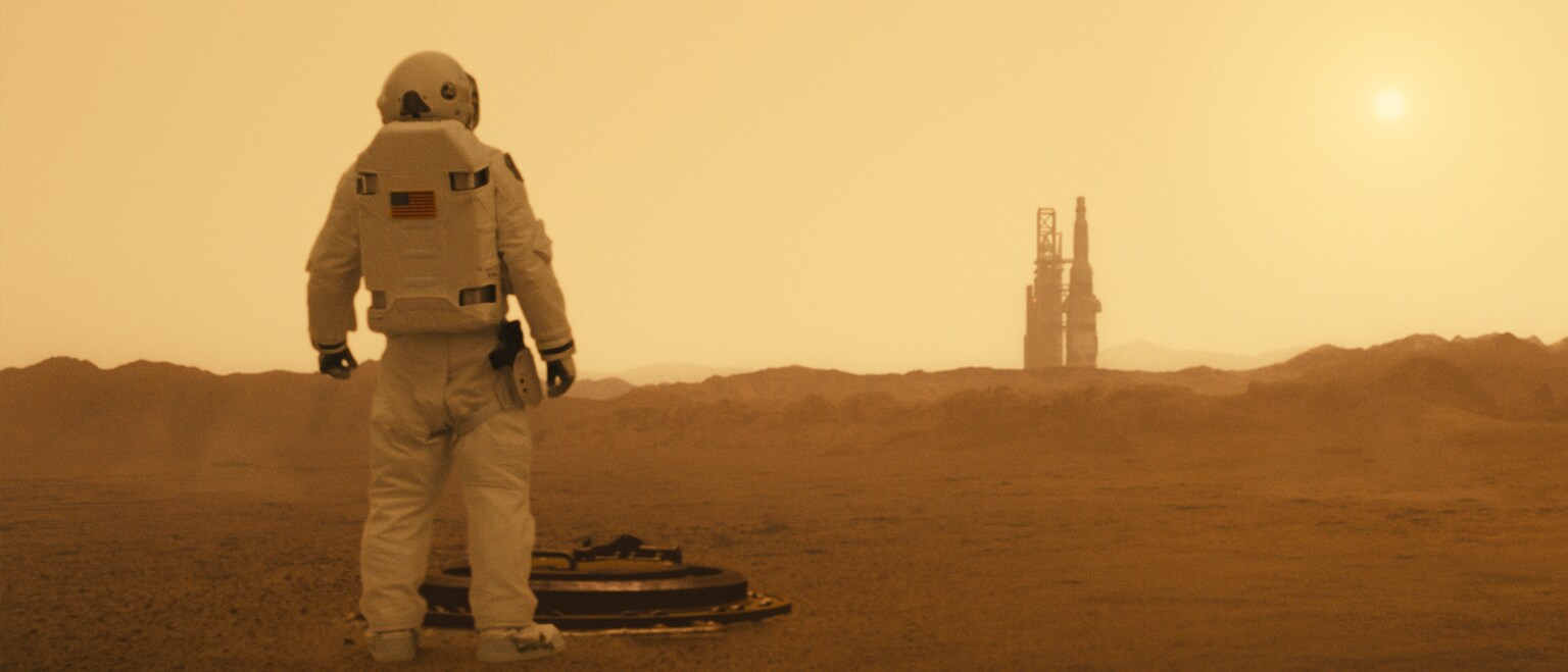 Image of an astronaut looking to the distance on a planet in the movie "Ad Astra".