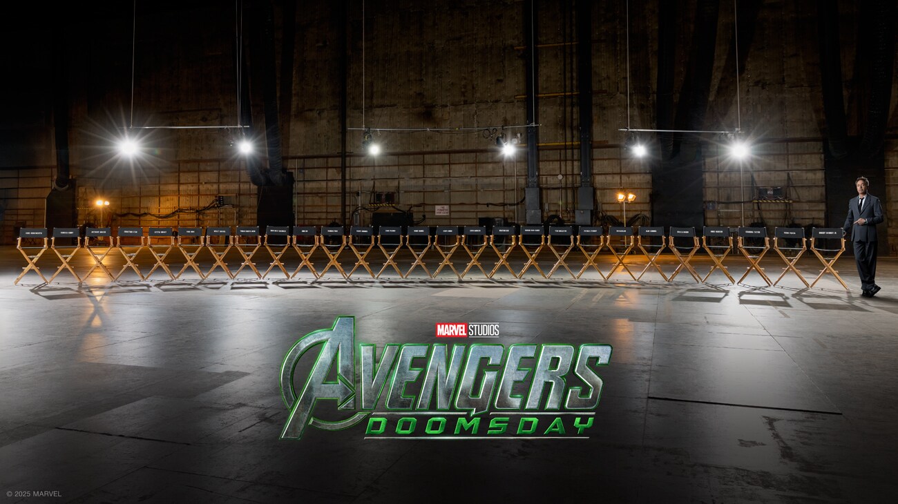 Image of several actors chairs lined up on a sound stage with actor Robert Downy Jr. standing to the far right of the image. | Marvel Studios | Avengers: Doomsday
