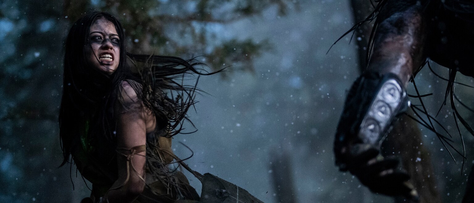 Image of a Native American looking at an individual in the foreground from the Hulu original movie, "Prey".