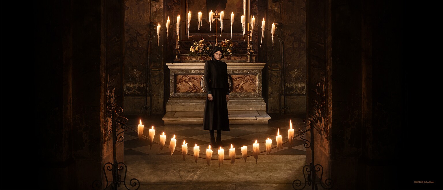 Nell Tiger Free as Margaret, standing in front of an alter with candles lit in the foreground and background, in 20th Century Studios’ THE FIRST OMEN. Photo credit: Moris Puccio/20th Century Studios. © 2023 20th Century Studios. All Rights Reserved.