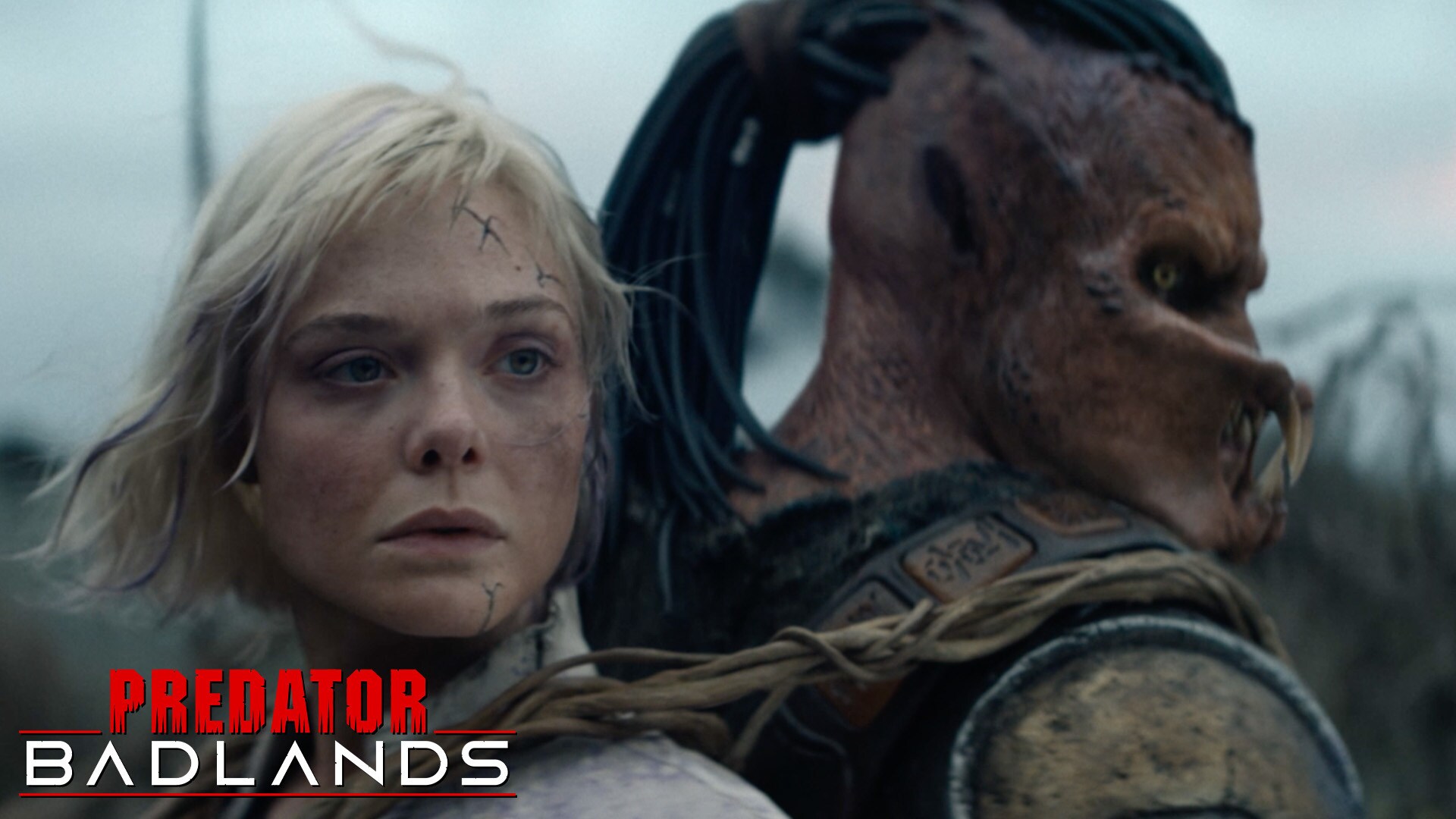 (L-R) Image of Elle Fanning as Thia and Dimitrius Schuster-Koloamatangi as Dek in 20th Century Studios' PREDATOR: BADLANDS film. Photo courtesy of 20th Century Studios. © 2025 20th Century Studios. All Rights Reserved. | Official Trailer