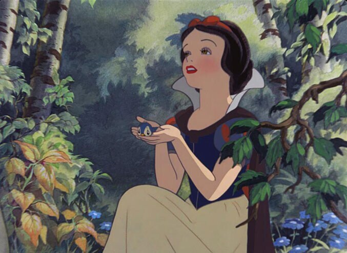 Snow White holding a blue bird in the animated movie "Snow White and the Seven Dwarfs"