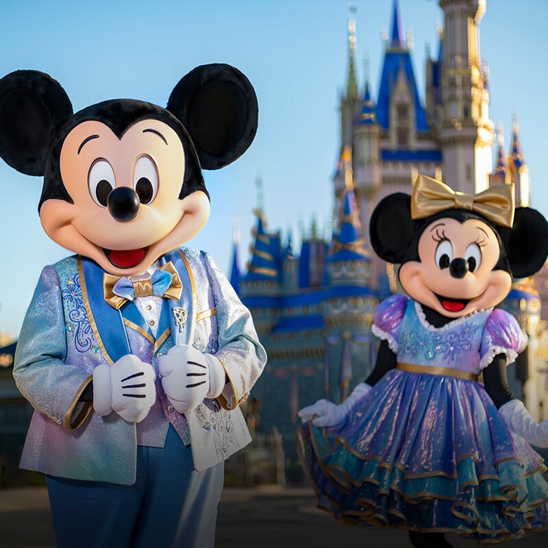 Mickey and Minnie stand in front of the castle at Walt Disney World.