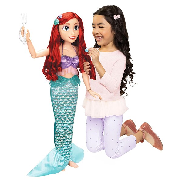 Photo of a girl playing with a Disney Princess Playdate Ariel Doll.