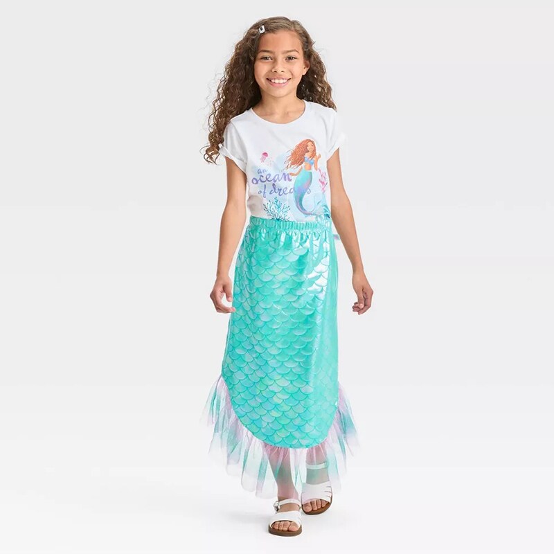 Image of a girl wearing a The Little Mermaid t-shirt and a skirt that looks like a mermaid tail.