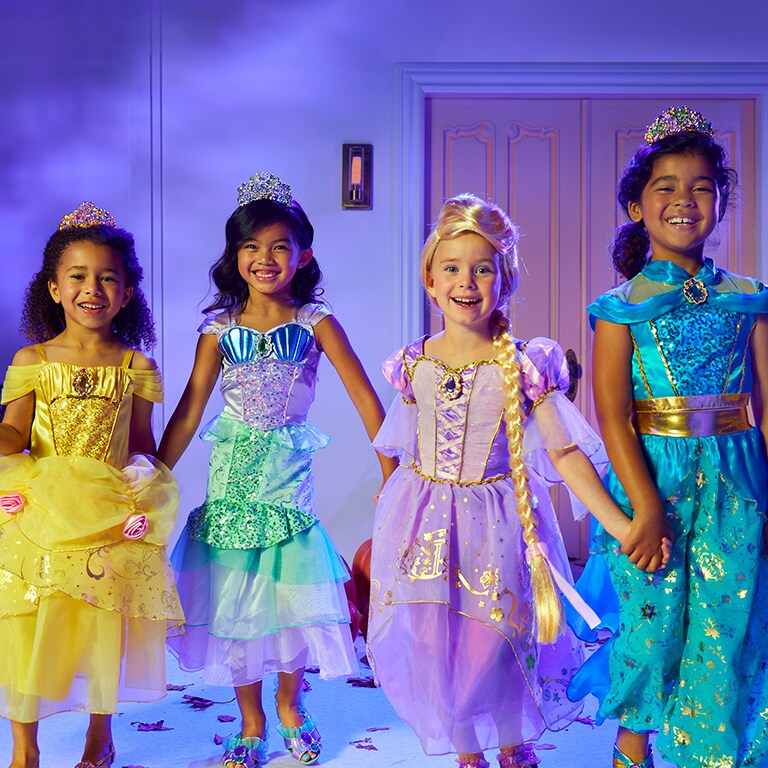 Photo of four girls wearings Disney Princess costumes (L-R) Belle, Ariel, Rapunzel, and Jasmine.