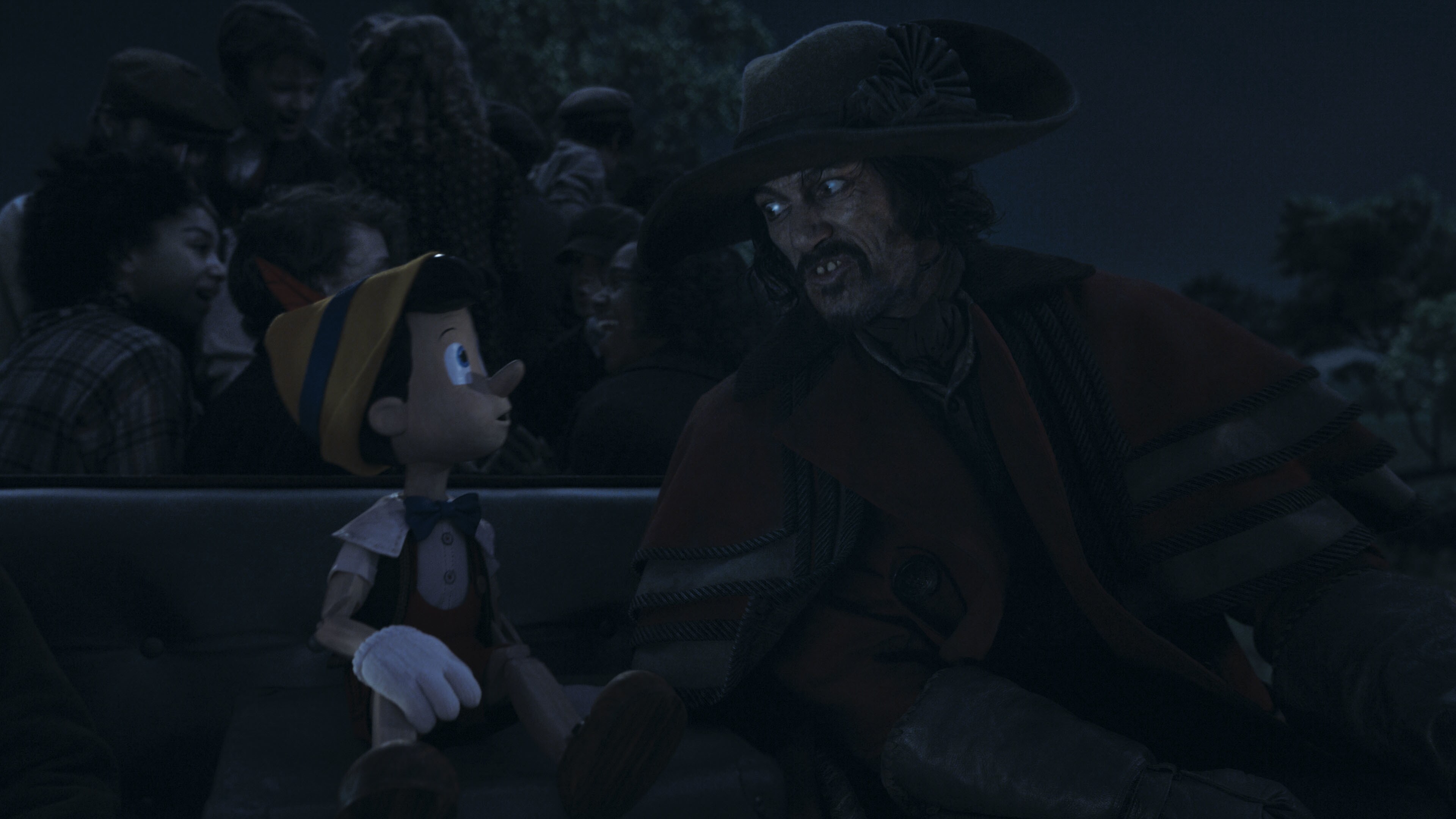 (L-R): Pinocchio (voiced by Benjamin Evan Ainsworth) and Luke Evans as The Coachman in Disney's live-action PINOCCHIO, exclusively on Disney+. Photo courtesy of Disney Enterprises, Inc. © 2022 Disney Enterprises, Inc. All Rights Reserved.