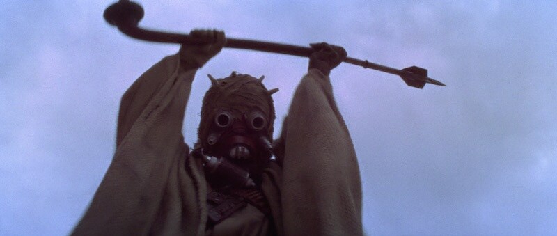 A Tusken Raider aggressively raising it's rifle