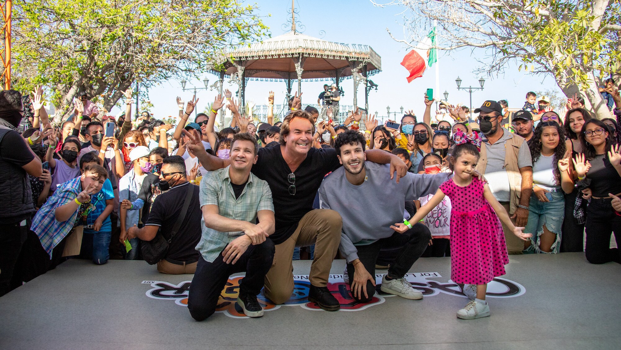 Jeremy Renner, Rory Millikin, and Sebastian Yatra celebrate with kids from Casa Hogar as seen on Disney's RENNERVATIONS. (Disney/Carlos Aboyo)