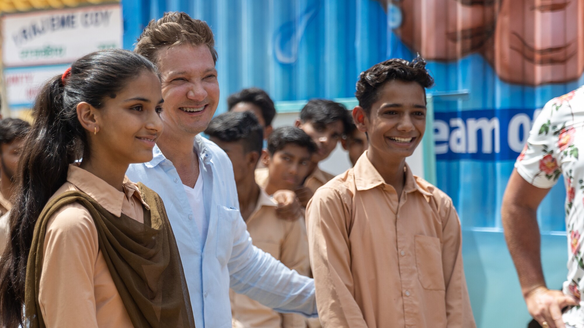 Jeremy Renner laughs with students during the delivery of the water treatment truck to Alwar, Rajasthan, India, as seen on Disney's RENNERVATIONS. (Disney/Mansi Midha)
