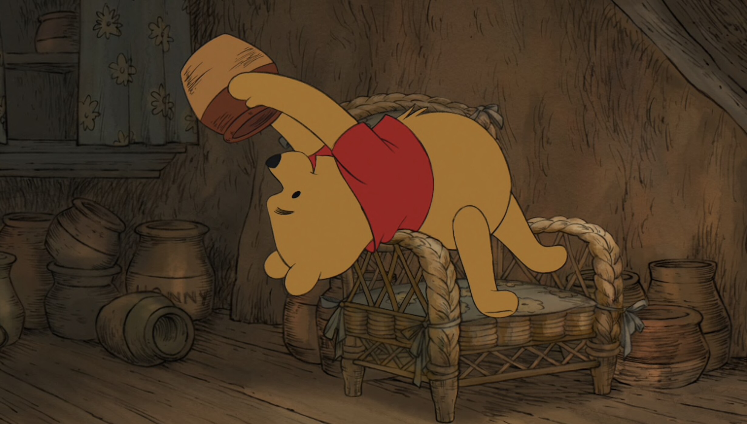 Winnie the Pooh bending backwards over his chair with a honey pot