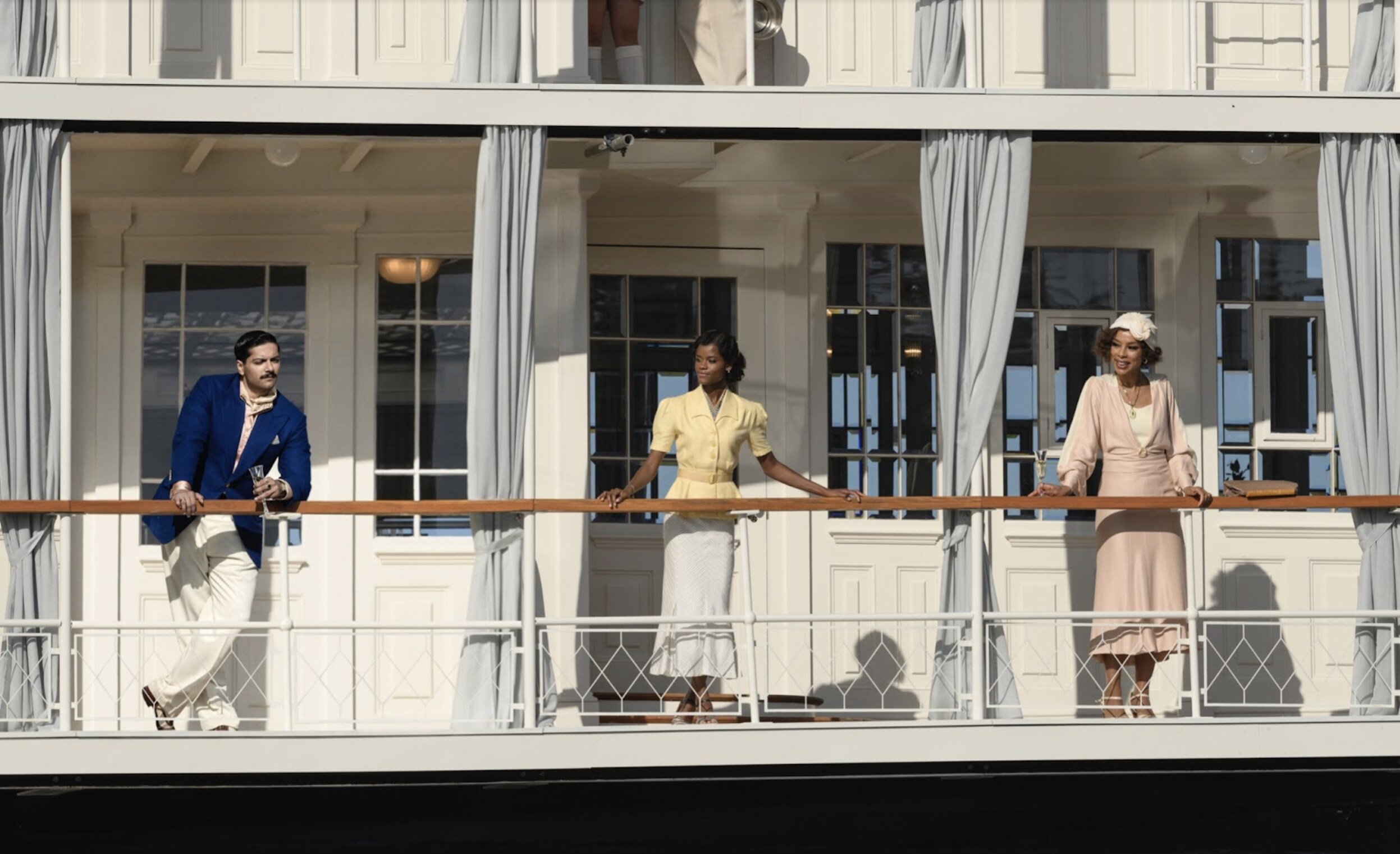 Three people look out from their balconies on Death on a Nile