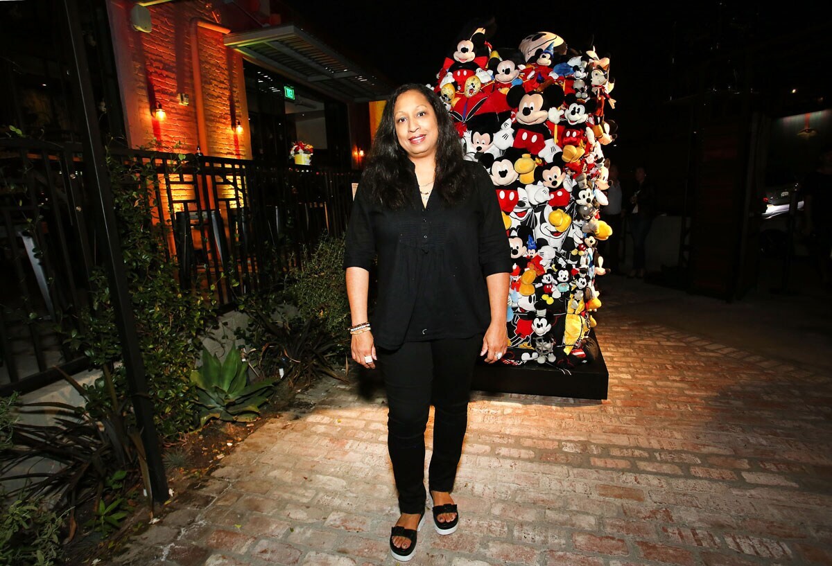 Shinique Smith standing in front of a Mickey Mouse art