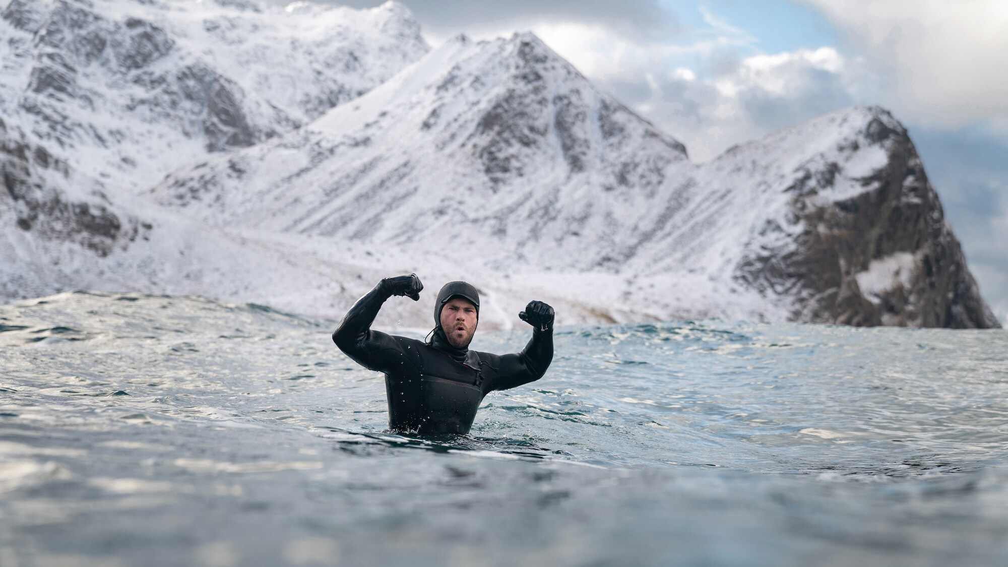 Chris Hemsworth celebrates while surfing. (National Geographic for Disney+/Craig Parry)