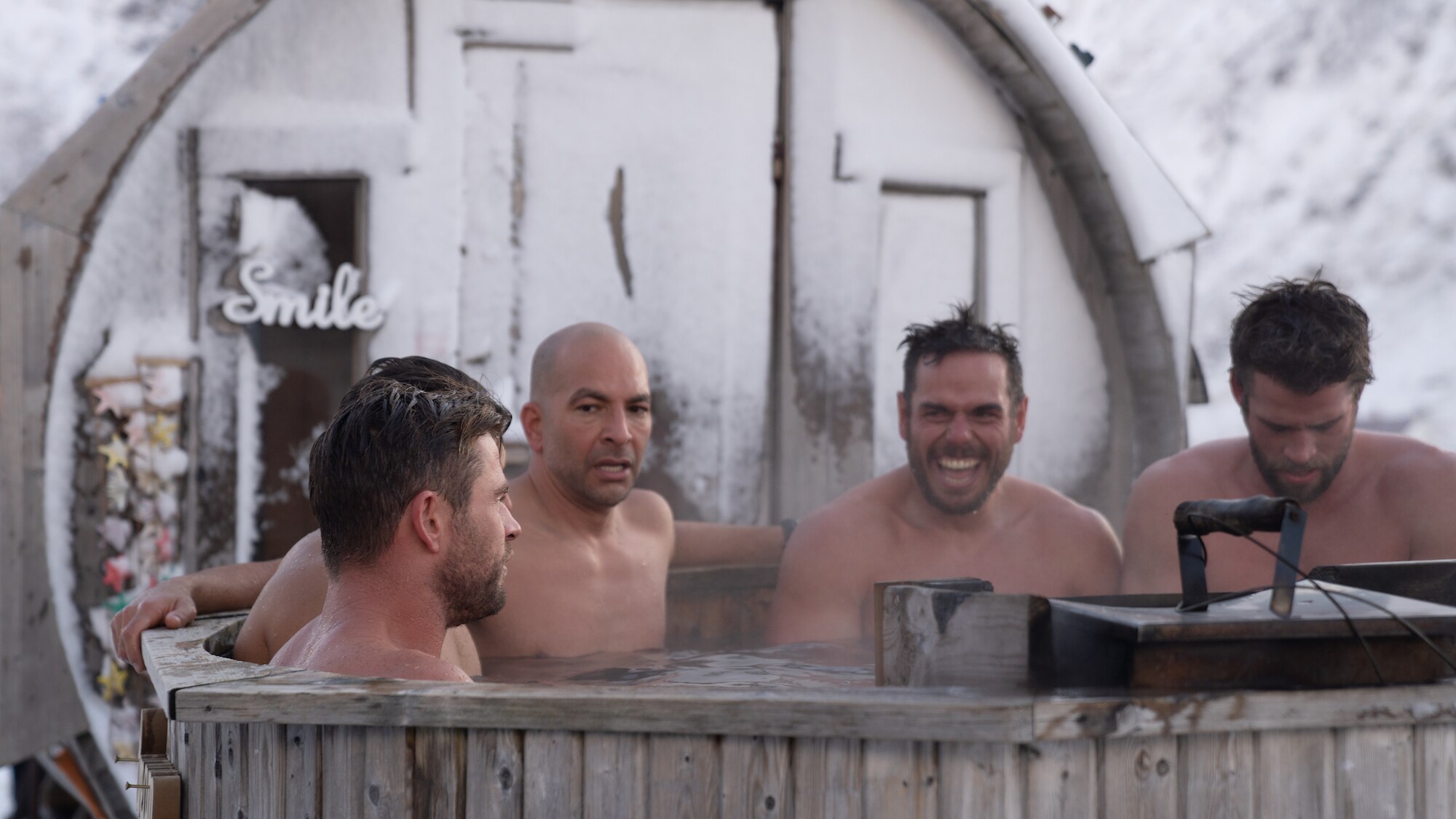 Chris, Liam, and Luke Hemsworth sit in a hot tub with Peter Attia and Ross Edgley. (National Geographic for Disney+/Craig Parry)
