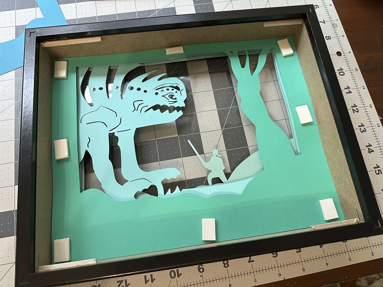 7. Continue sticking layers and stacked mounting tape in the same spots for the rancor, single tree, and double tree layers.