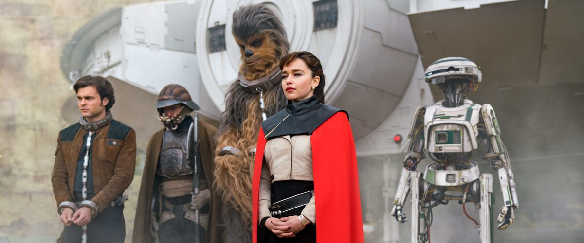 Qi'ra and Beckett's gang standing in front of the Millennium Falcon