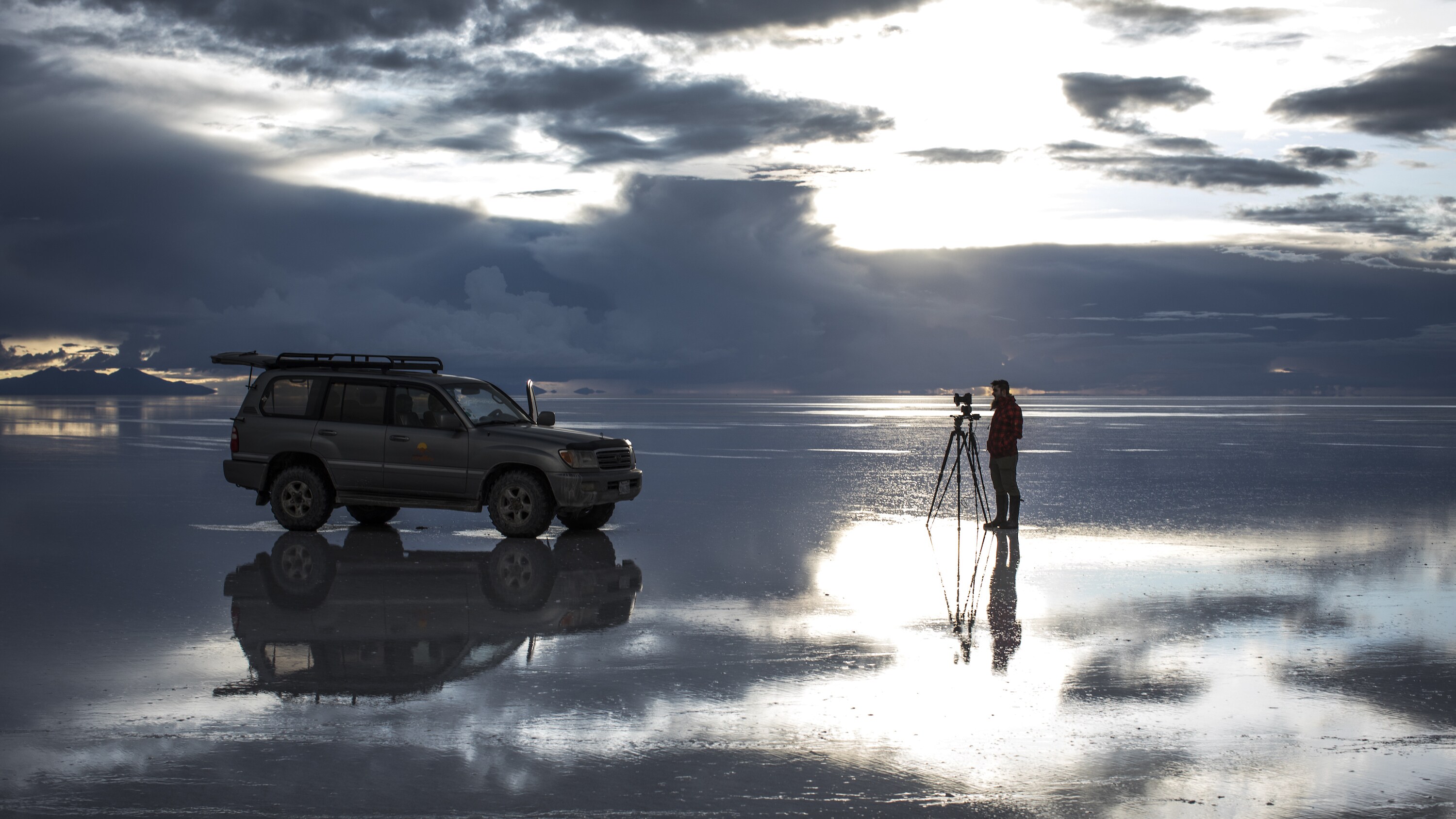 WELCOME TO EARTH production researcher Kaide MacAulay standing by a timelapse camera. Each February seasonal rains transform the salt flats of Salar de Uyuni into the biggest mirror on the planet.  (National Geographic/Freddie Claire)