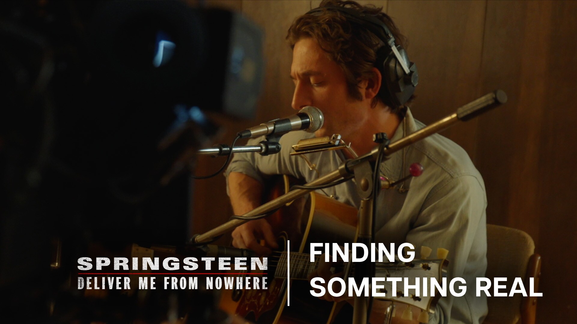 Image of Bruce Springsteen (actor Jeremy Allen White) sitting while playing a guitar in a studio setting. | 20th Century Studios | Springsteen: Deliver Me From Nowhere | Finding something real