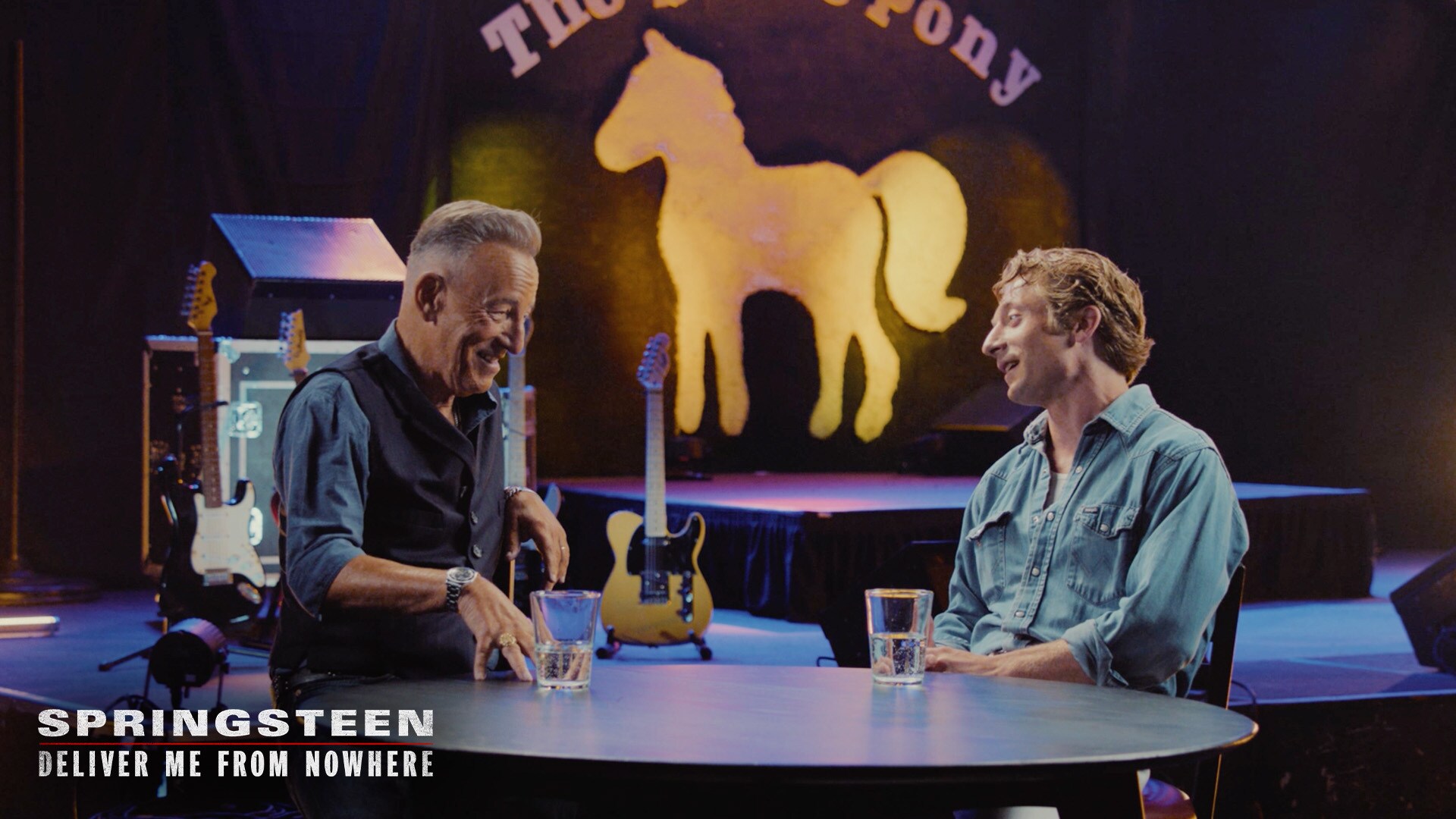 Image of Bruce Springsteen and actor Jeremy Allen White sitting at a table talking. | 20th Century Studios | Springsteen: Deliver Me From Nowhere