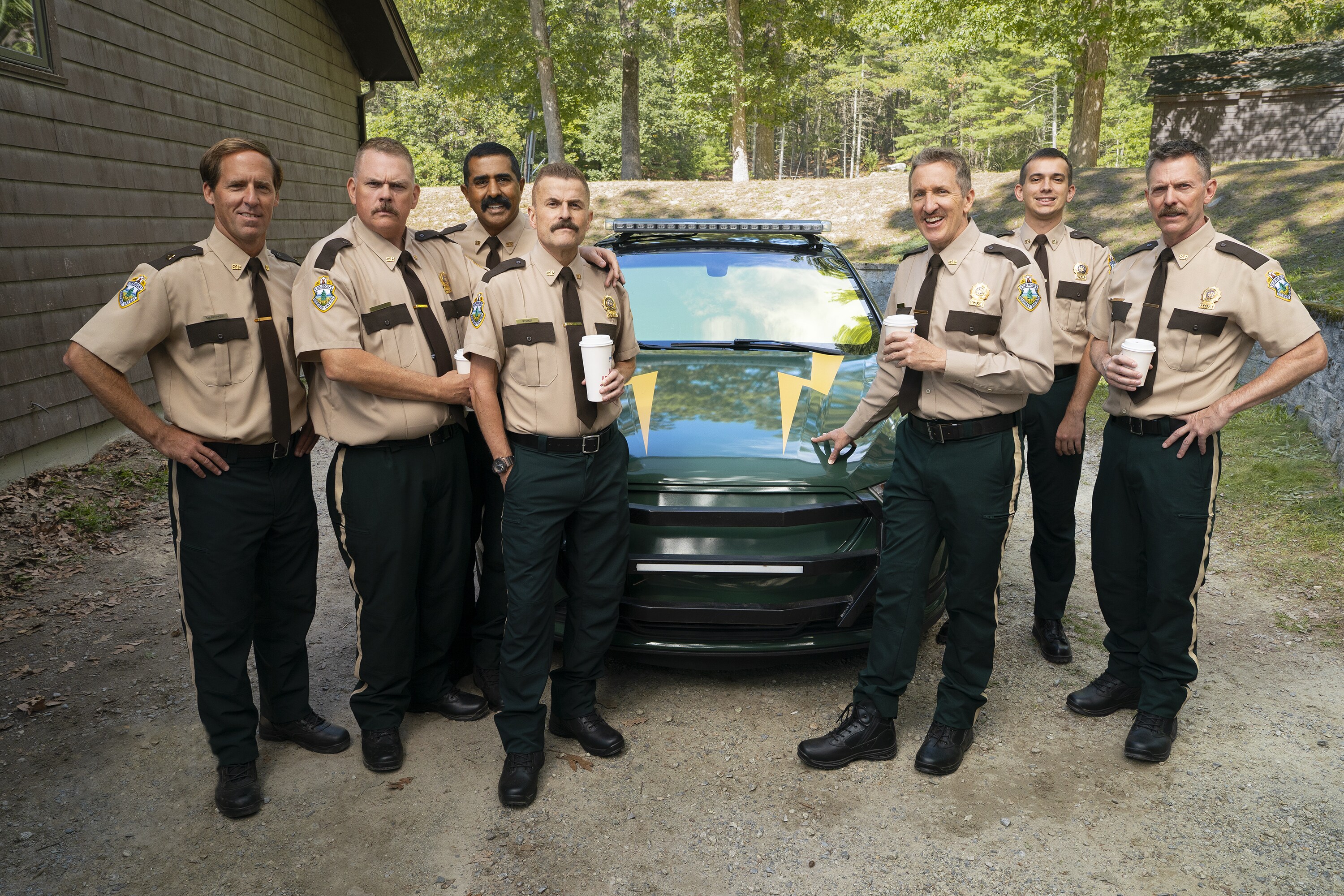 Nat Faxon, Kevin Heffernan, Jay Chandrasekhar, Steve Lemme, Paul Soter, Andrew Dismukes, and Erik Stolhanske on the set of SUPER TROOPERS 3. Photo by Patrick Harbron, Courtesy of Searchlight Pictures. © 2026 Searchlight Pictures. All Rights Reserved.