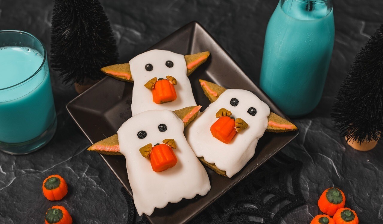 Three ghostly Grogu cookies with blue milk