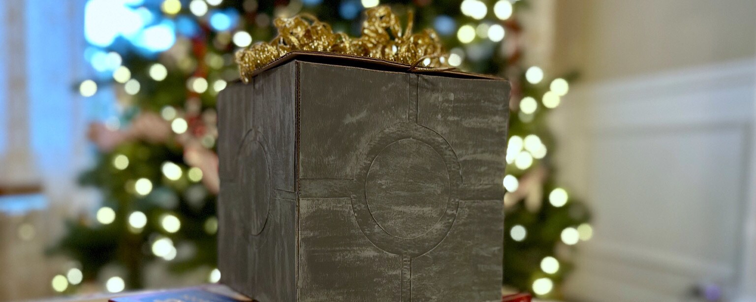 Crafted Star Wars-style gray gift crate in front of Christmas tree.