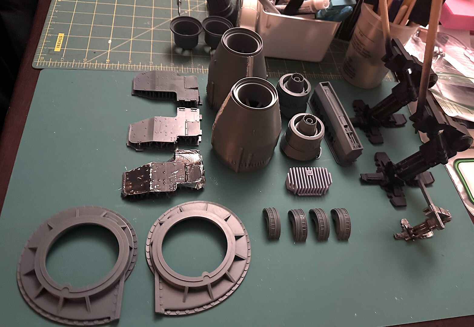 Adapting components from classic model sets of real world vehicles, Aron used a piece from a Saturn V rocket shell (center) for the freighter’s engines whilst adapting flanges from the wheel mount of World War II-era Panzer tank (lower left) for the engines’ base. Also visible is a piece from a Rebel snowspeeder.