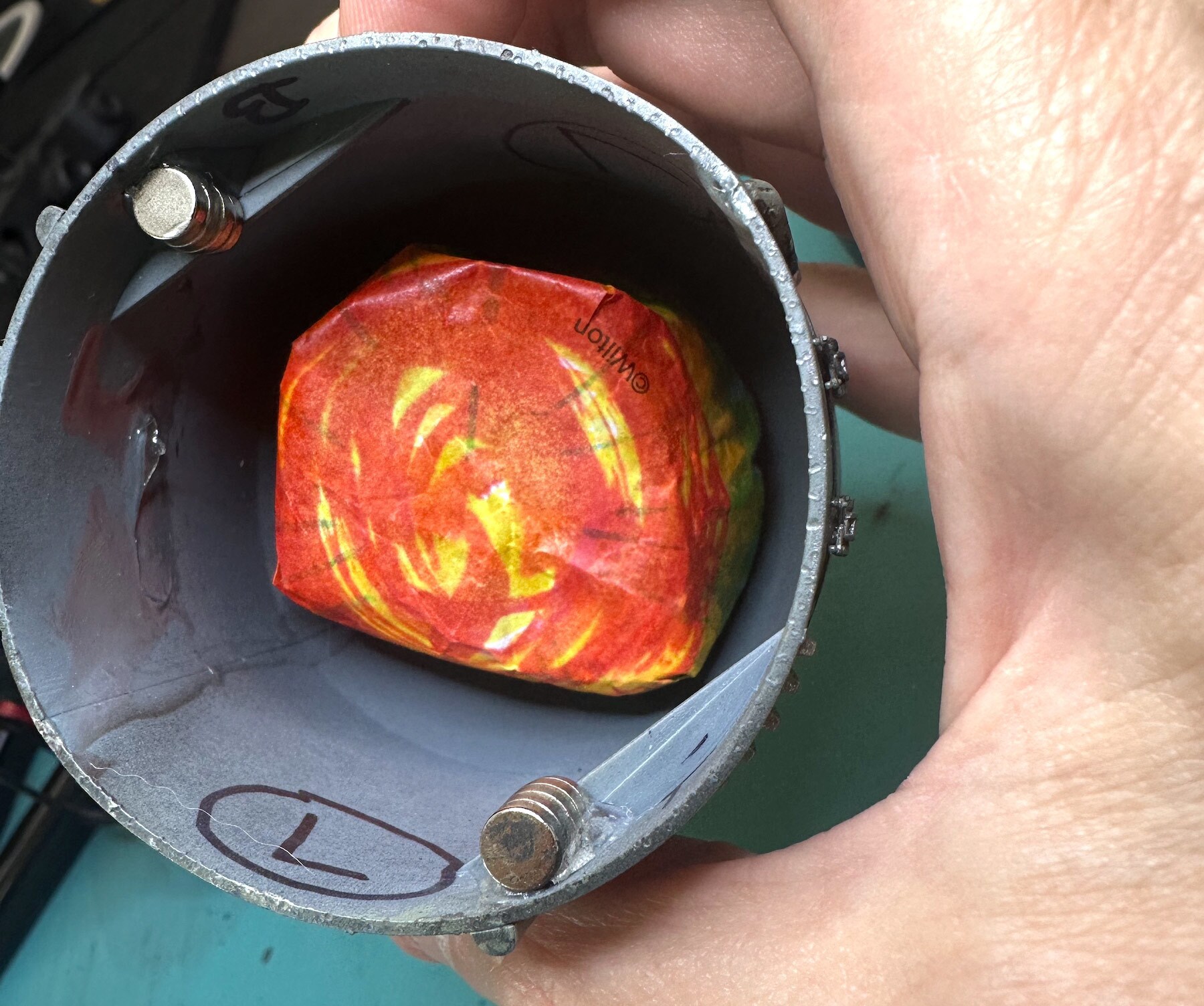 The cupcake holder, hardened in resin, placed over the light source inside the engine.