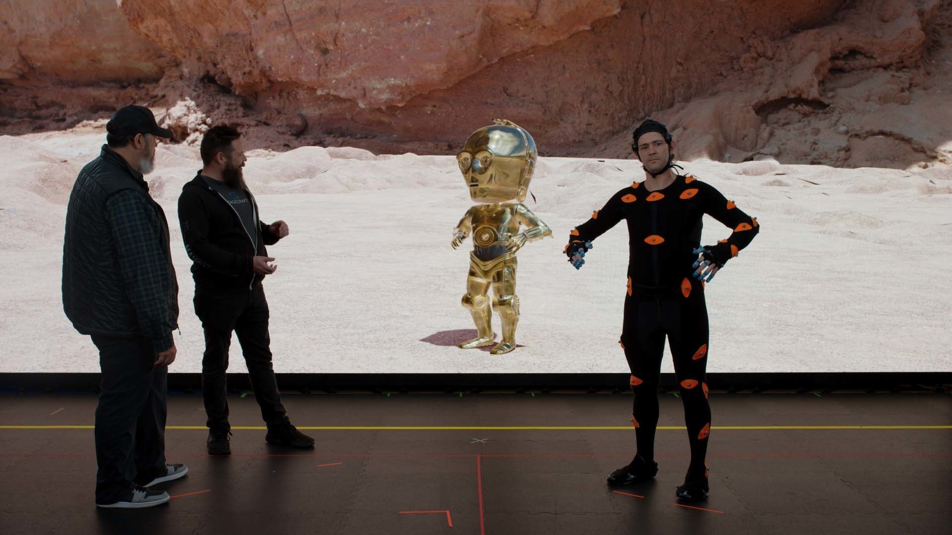A performer in a motion capture suit lends movement to a Chibi-style C-3PO.