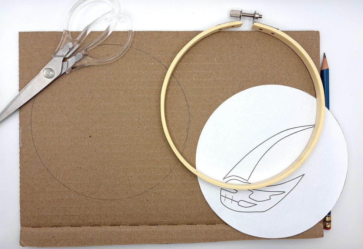 Separate the embroidery hoops. Trace the inside of the larger hoop on a scrap of cardboard and cut it out.