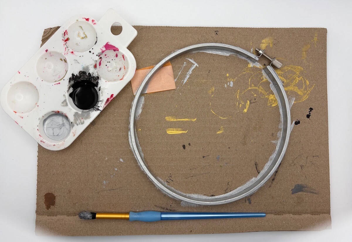 Paint the larger embroidery hoop silver and let it dry.