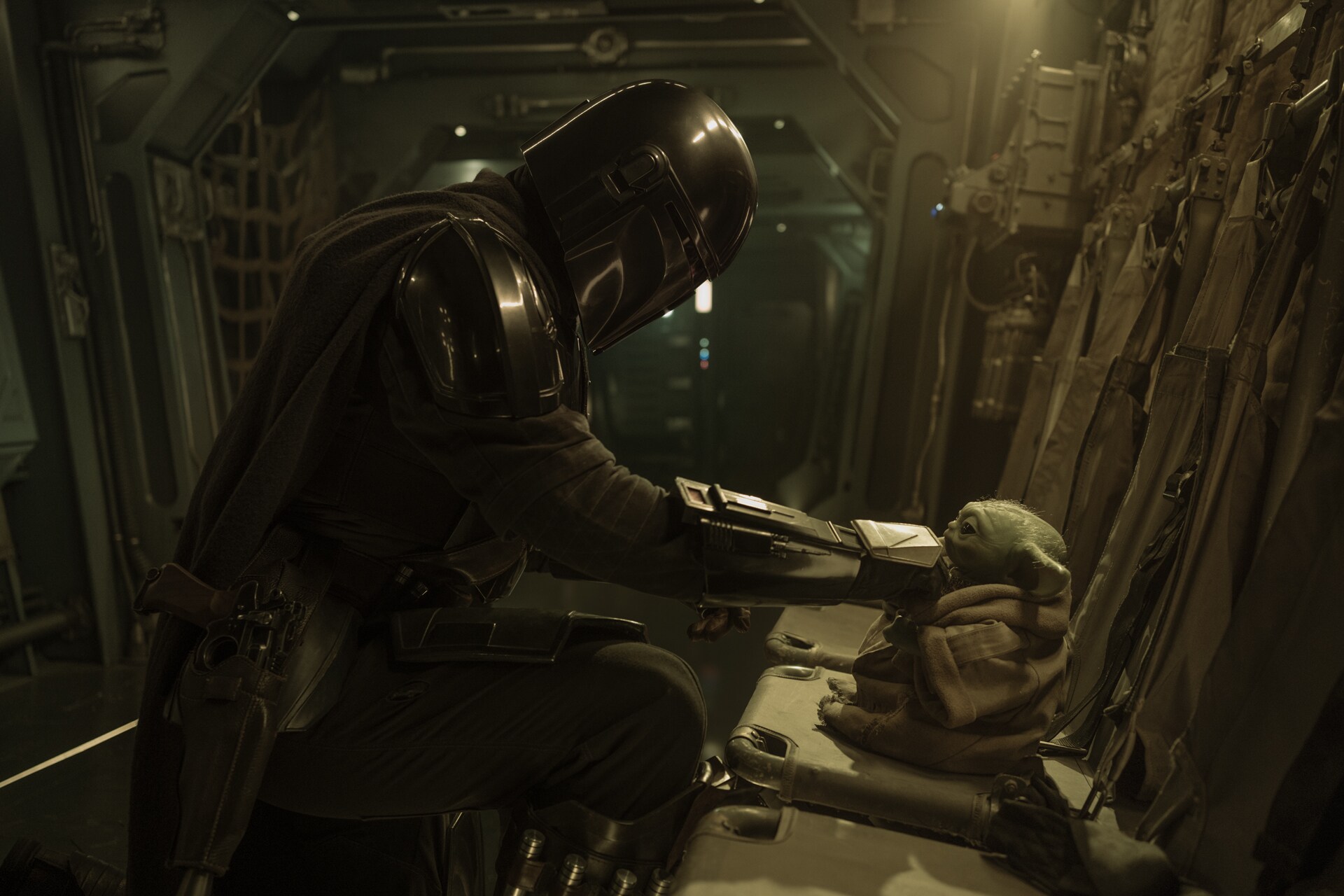 Din helps Grogu with his armor.