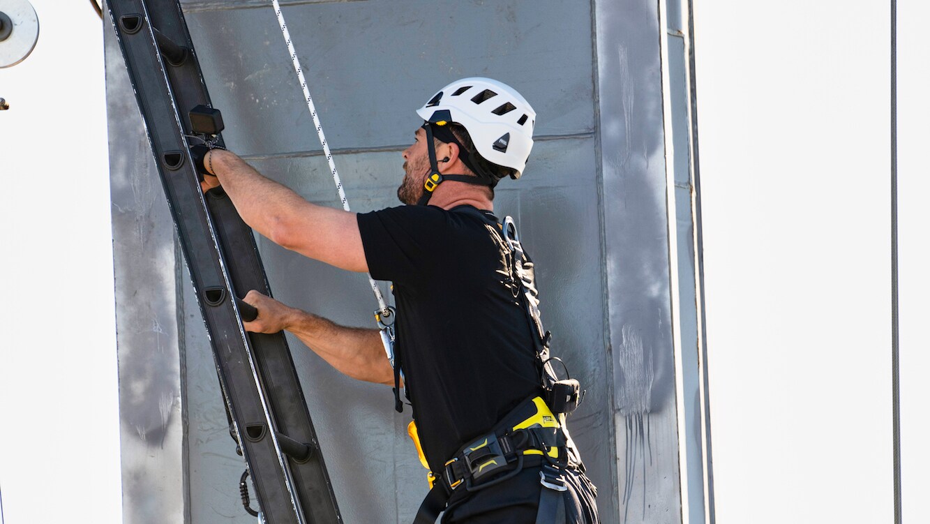 Chris Hemsworth climbs a ladder towards his epic crane walk. (National Geographic for Disney+/Craig Parry)